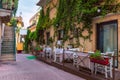 Beautiful old town of Taormina with small streets, flowers. Architecture with archs and old pavement in Taormina. Colorful narrow