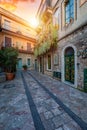 Beautiful old town of Taormina with small streets, flowers. Architecture with archs and old pavement in Taormina. Colorful narrow
