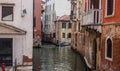 Beautiful old venetian street with old shabby colorful buildings and tourists in gondola.