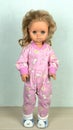 Beautiful vintage baby doll in pink overalls, with golden hair Royalty Free Stock Photo