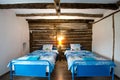 Beautiful old vintage country house - bedroom interior with wood beam ceiling and blue duvets and sheets Royalty Free Stock Photo