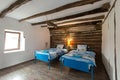 Beautiful old vintage country house - bedroom interior with wood beam ceiling and blue duvets and sheets Royalty Free Stock Photo