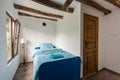 Beautiful old vintage country house - bedroom interior with wood beam ceiling and blue duvets and sheets Royalty Free Stock Photo