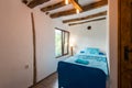 Beautiful old vintage country house - bedroom interior with wood beam ceiling and blue duvets and sheets Royalty Free Stock Photo