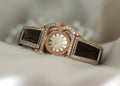 Beautiful old vintage gold watches with sparkling gem stones on a soft bokeh background