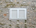 Beautiful old window frame with white wooden shutters and ancient pale stone wall. Rural antique window frame. Design element. Tem