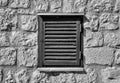 Beautiful old window frame with old wooden shutters on ancient pale rock wall. Rural antique window frame. Design element.