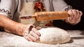 Beautiful and old women`s hands knead the dough from which they will then make bread, pasta or pizza. A cloud of flour flies Royalty Free Stock Photo