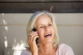 Beautiful older woman laughing on cell phone outside Royalty Free Stock Photo