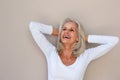 Beautiful older woman leaning with hands behind head