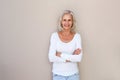 Beautiful older woman standing and smiling with arms crossed Royalty Free Stock Photo