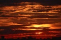 Beautiful and ominous red sunset over the city. The sun`s rays make their way through the bizarre cloud structure