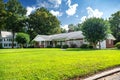 beautiful one story home with a large manicured lawn and trees in the front yard Royalty Free Stock Photo