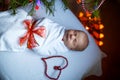 One week old newborn baby wrapped in blanket near Christmas tree Royalty Free Stock Photo