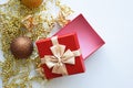 An open red gift box and golden beads and a Christmas ball. background for decoration for the winter holidays Christmas and New Ye Royalty Free Stock Photo