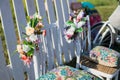 Beautiful open terrace in the garden with tiffany coloured vintage white chairs, colorful velvet pillow and fence palisade