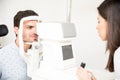 Young optometrist with autorefractor checking man patient at eye Royalty Free Stock Photo