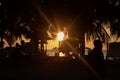 Beautiful orange beach dusk scene with palms and people silhouette