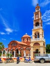 Beautiful orange Greek church on island of Rhodes. The bright sky with clouds