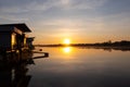 Beautiful orange sunrise over the river. Golden twilight, sunlight reflected in water ripples. Royalty Free Stock Photo