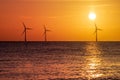 Beautiful orange sunrise with silhouetted offshore wind farm turbines Royalty Free Stock Photo