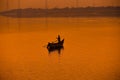 beautiful orange sunset landscape with fisherman on the small boat