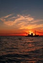 Beautiful orange sunset on sea water. Transport ship on the dock in the evening on seacoast. Shipping logistic by sea Royalty Free Stock Photo