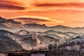 Beautiful orange sunset sky with lenticular clouds over a winter mountain landscape Pestera, Moeciu