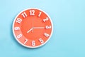 Beautiful Orange wall clock on blue background ,concept of Start the morning to work