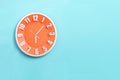 Beautiful Orange wall clock on blue background ,concept of Start the morning to work Royalty Free Stock Photo