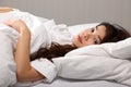 Beautiful oriental woman lying in bed eyes open Royalty Free Stock Photo