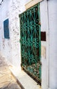 Beautiful ornamental windows on white wall typical for Tunisia / Traditional old green window with ornament decorative forging.