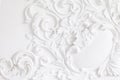 Beautiful ornate white decorative plaster mouldings in studio. The white wall is decorated with exquisite elements of Royalty Free Stock Photo