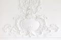 Beautiful ornate white decorative plaster mouldings in studio. The white wall is decorated with exquisite elements of Royalty Free Stock Photo