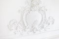 Beautiful ornate white decorative plaster mouldings in studio. The white wall is decorated with exquisite elements of Royalty Free Stock Photo