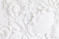 Beautiful ornate white decorative plaster mouldings in studio. The white wall is decorated with exquisite elements of