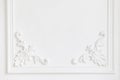 Beautiful ornate white decorative plaster mouldings in studio. The white wall is decorated with exquisite elements of Royalty Free Stock Photo