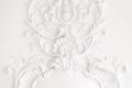 Beautiful ornate white decorative plaster mouldings in studio. The white wall is decorated with exquisite elements of Royalty Free Stock Photo