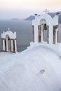 Arch with a bell, white houses and church with blue domes in Oia or Ia at golden sunset, island Santorini, Greece. - Immagine Royalty Free Stock Photo