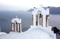 Arch with a bell, white houses and church with blue domes in Oia or Ia at golden sunset, island Santorini, Greece. - Immagine Royalty Free Stock Photo