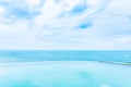 Beautiful outdoor infinity swimming pool in hotel resort with sea ocean view and white cloud blue sky Royalty Free Stock Photo