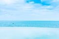 Beautiful outdoor infinity swimming pool in hotel resort with sea ocean view and white cloud blue sky Royalty Free Stock Photo