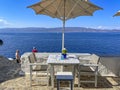 A beautiful outdoor restaurant cafe with a gorgeous view towards the Argosaronic gulf at the picuresque Greek Island of Hydra