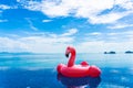 Beautiful outdoor swimming pool in hotel resort with flamingo float around sea ocean white cloud on blue sky Royalty Free Stock Photo