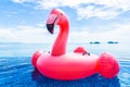 Beautiful outdoor swimming pool in hotel resort with flamingo float around sea ocean white cloud on blue sky Royalty Free Stock Photo