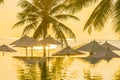 Beautiful outdoor tropical nature landscape of swimming pool in hotel resort with coconut palm tree umbrella and chair nearly sea Royalty Free Stock Photo