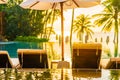 Beautiful outdoor tropical nature landscape of swimming pool in hotel resort with coconut palm tree umbrella and chair nearly sea Royalty Free Stock Photo