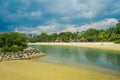 Beautiful outdoor view of unidentified poople enjoying the yellow sand and tropical beach in sentosa and swimming in a