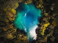 Beautiful overhead aerial photo of a crystal clear lake with boats and boats` trails