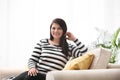 Beautiful overweight woman on sofa in room. Plus size model